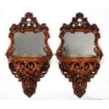 A PAIR OF FRENCH CARVED WALNUT MIRROR BACKED WALL BRACKETS, C1870, OF SCROLLING FOLIATE DESIGN