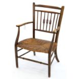 AN ARTS AND CRAFTS RUSH SEATED ASH ELBOW CHAIR, SEAT HEIGHT 35CM, 53CM W Some slight movement to