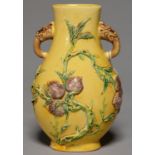 A CHINESE YELLOW, GREEN AND AUBERGINE GLAZED BISCUIT VASE, MOULDED WITH FRUITING PEACH TREES, A