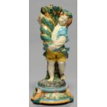 A VICTORIAN FIGURAL MAJOLICA STAND, C1880, IN THE FORM OF A YOUNG GRAPE HARVESTER WITH A CORNUCOPIA,