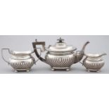 AN EDWARD VII  GADROONED  SILVER TEA SERVICE, ON BUN FEET, TEAPOT 11CM H, BY J GLOSTER LTD,