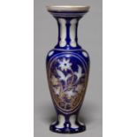 A BOHEMIAN CASED GLASS VASE, C1860, OF OPAL GLASS CASED IN ROYAL BLUE AND CUT WITH A PANEL OF A