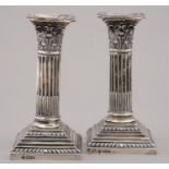 A PAIR OF VICTORIAN DWARF SILVER COLUMNAR CANDLESTICKS WITH STOP FLUTED SHAFT AND CORINTHIAN