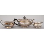 A VICTORIAN SILVER BACHELORS TEA SERVICE OF PROW FORM, THE LOWER BODY REEDED, ACANTHUS CAPPED