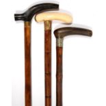 THREE VICTORIAN AND EDWARDIAN BAMBOO WALKING CANES WITH IVORY OR HORN TAU HANDLE AND GILTMETAL OR