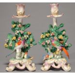 A PAIR OF CONTINENTAL PORCELAIN PARROT  CANDLESTICKS, 19TH C, IN BOW STYLE, THE BRIGHTLY PLUMAGED