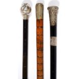 ONE BAMBOO AND TWO EBONY WALKING CANES, EACH WITH SILVER OR OTHER POMMEL, TWO MILITARY (ROYAL