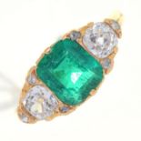 AN EMERALD AND DIAMOND THREE STONE RING,  THE STEP CUT EMERALD FLANKED BY CUSHION SHAPED OLD CUT