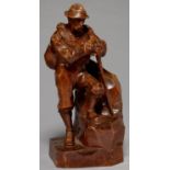 A SWISS LIMEWOOD STATUETTE OF AN ALPINE GUIDE, C1900, CARVED STANDING ON ROCKS, A COIL OF ROPE