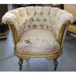 A FRENCH GILTWOOD TUB CHAIR, C1870, IN BUTTONED UPHOLSTERY WITH OUT SCROLLED AND LEAF CARVED