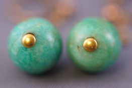 A yellow metal pair of drop earrings each having a circular polished green jade bead