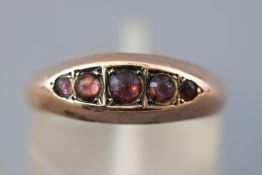 A rose metal half hoop ring set with five circular cabochon cut purple stones