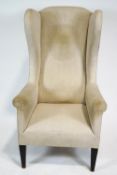 A wingback armchair on square tapering mahogany legs,