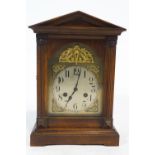 A 20th century mantel clock, with brass arched dial enclosed with a beech case,