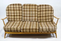 A blonde Ercol three seat sofa, 86cm high x 176cm wide x 73cm deep,