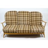 A blonde Ercol three seat sofa, 86cm high x 176cm wide x 73cm deep,