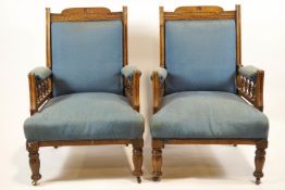 A pair of late Victorian mahogany show frame armchairs, on turned legs with casters,