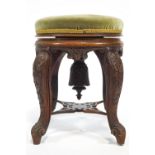 A Victorian mahogany piano stool on four carved legs linked by a pierced stretcher,