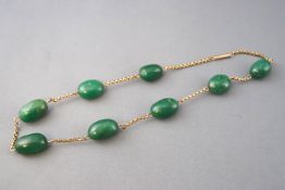 A yellow metal belcher chain necklace having eight oval polished aventurine quartz beads