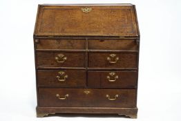 A George III Provincial oak bureau, with fall front on lopers,