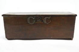 A 17th century oak plank coffer, with later brass stud decoration,