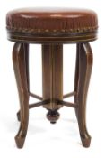 An early 20th century mahogany four cabriole leg piano stool with rising round seat,
