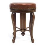 An early 20th century mahogany four cabriole leg piano stool with rising round seat,