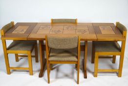 A 1970's Danish teak tile set Farstrup drop leaf dining table with four chairs,