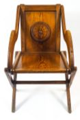 An oak Glastonbury chair, in traditional form, the back carved with a roundel,