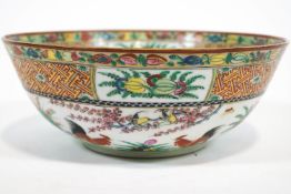 A Chinese porcelain bowl, painted in enamels in Canton style, with cockerels in a garden,