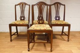 A set of four Edwardian mahogany Hepplewhite camel back style dining chairs with pierced splats