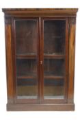 A 19th century mahogany standing bookcase with two glazed doors on plinth base,