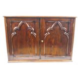A pine side cabinet, the two panelled doors with Gothic style applied arches,