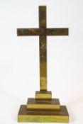 A brass cross on a stepped base,