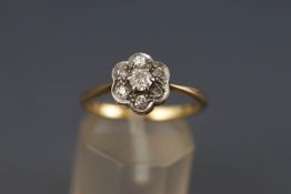 A yellow and white metal cluster ring. Set with seven old European cut diamonds.
