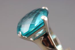 A rhodium plated dress ring by Swarovski. Having a large faceted blue Swarovski crystal.