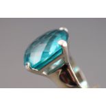 A rhodium plated dress ring by Swarovski. Having a large faceted blue Swarovski crystal.