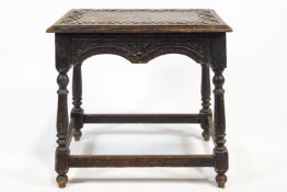 A 19th century carved oak Elizabethan coffin stool style table with arcaded chip carved top