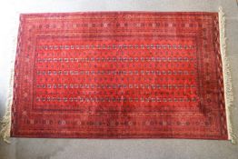 An Afghan carpet with red ground,