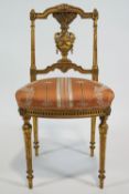 A French style gilt gesso salon chair with carved cresting over an urn splat with ears of wheat