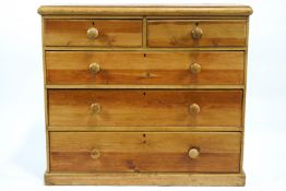 A 19th century pine chest of two short and three long drawers with turned handles on plinth base,