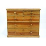 A 19th century pine chest of two short and three long drawers with turned handles on plinth base,