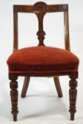 A Victorian mahogany chair with carved shaped back, stuff over seat on turned tapering legs,
