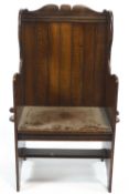 An oak lambing chair, with slatted back, shaped sides and plank seat,