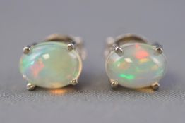 A white metal pair of single stone stud earrings.