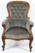 A Victorian mahogany show frame armchair with button back on cabriole legs and casters,
