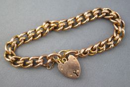 A yellow metal curb and roller bracelet. Padlock clasp with safety chain.