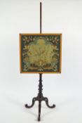 A Victorian firescreen with tapestry banner on a mahogany pole on tripod carved cabriole leg base,