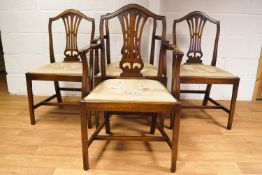 A set of four mahogany Hepplewhite camel back style dining chairs with pierced splats and drop in