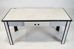 A 1950's white enamel table with black enamel banding and one frieze drawer on square legs,